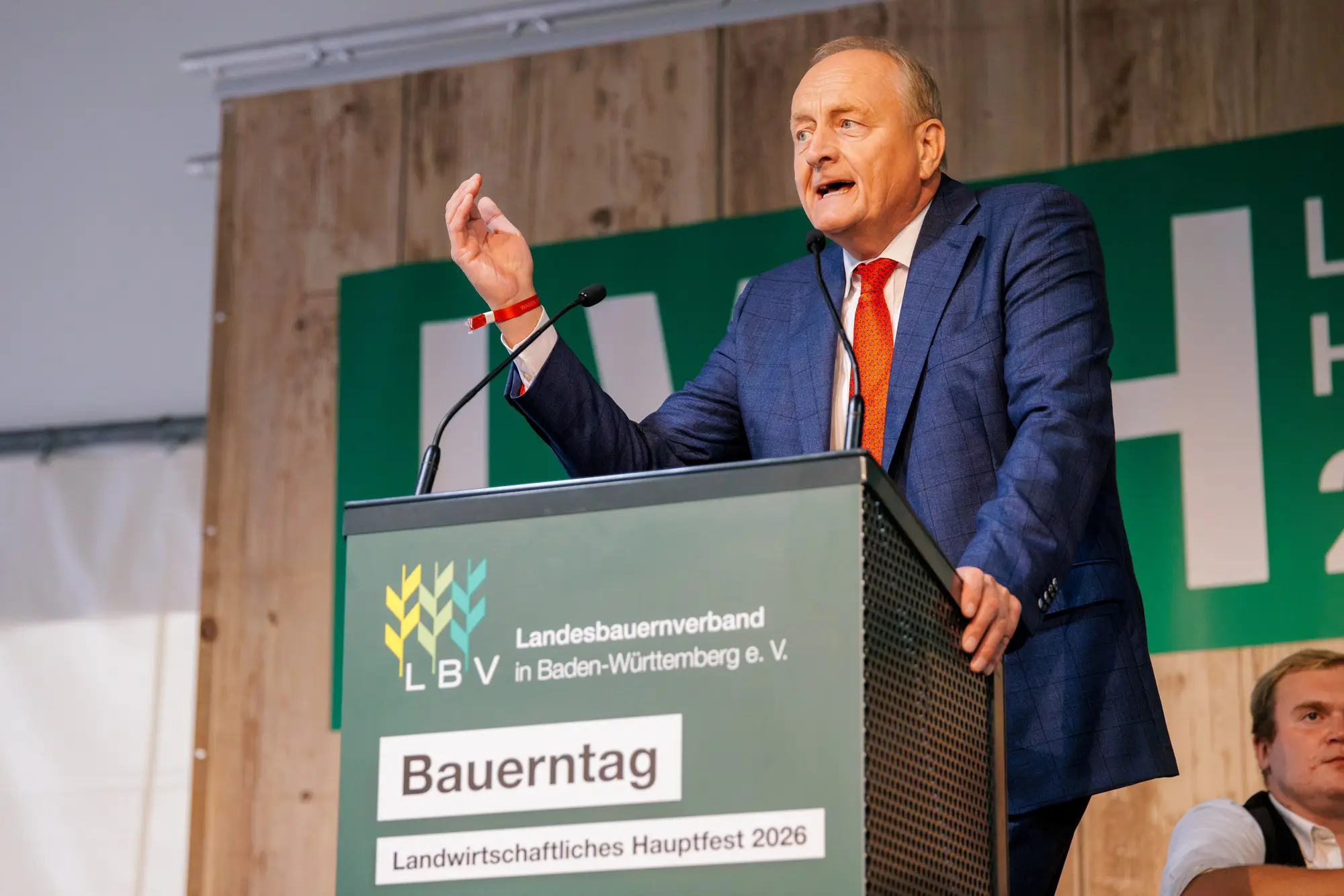 LBV-Präsident Joachim Rukwied am Rednerpult des Bauerntags vor der Rückwand des Landwirtschaftlichen Hauptfests