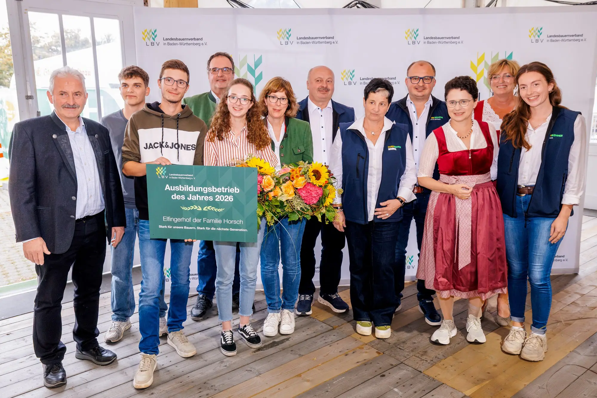 Gruppenbild zur Auszeichnung Ausbildungsbetrieb des Jahres 2026 mit Urkunde und Blumen