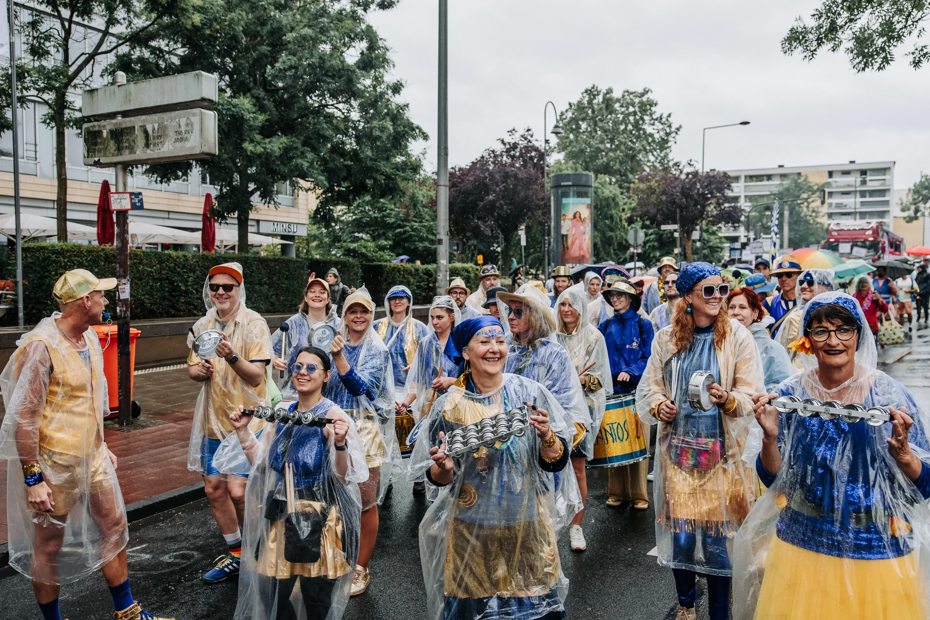 Fußgruppe in blau-gelben Regencapes beim CSD Köln