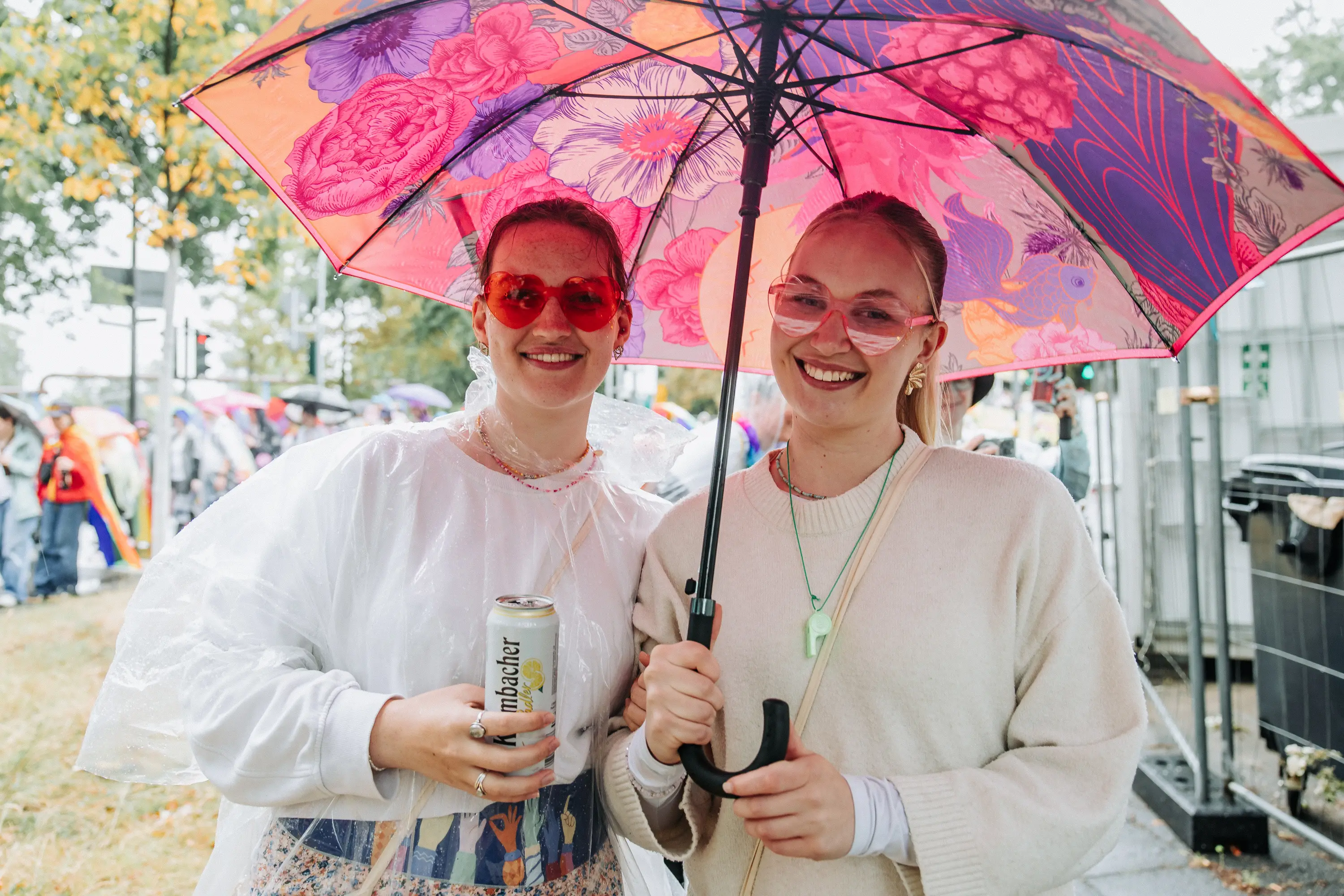 Zwei Besucherinnen teilen sich einen Regenschirm bei der Cologne Pride