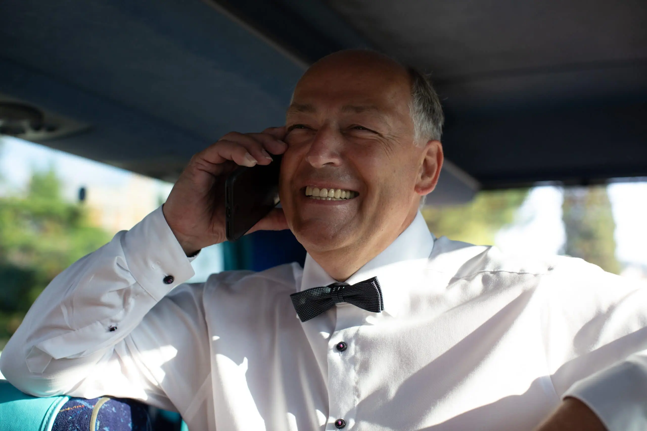 Hochzeitsgast lacht während eines Telefonats bei der Feier
