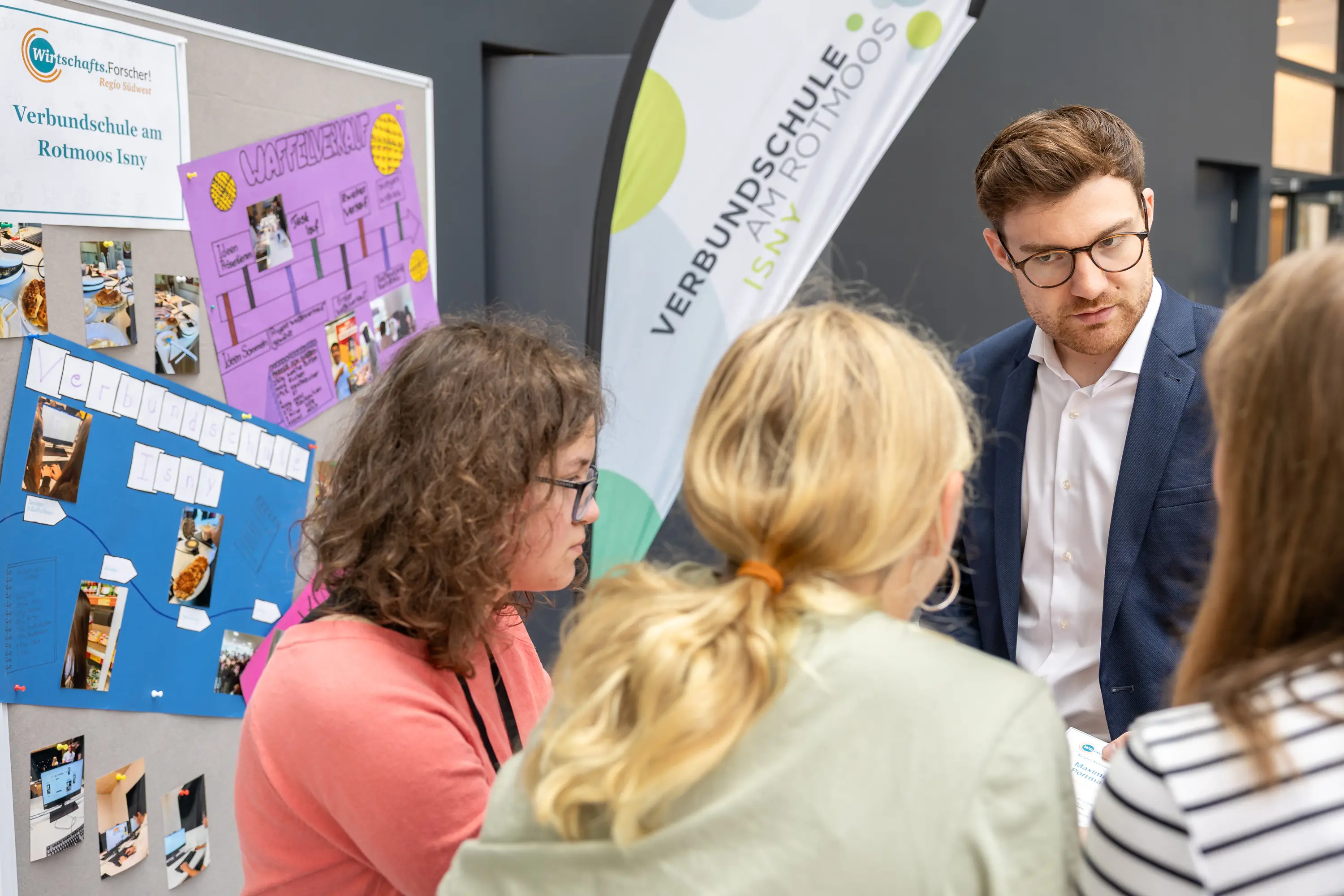 Projektplakat einer Verbundschule wird den Gästen erklärt
