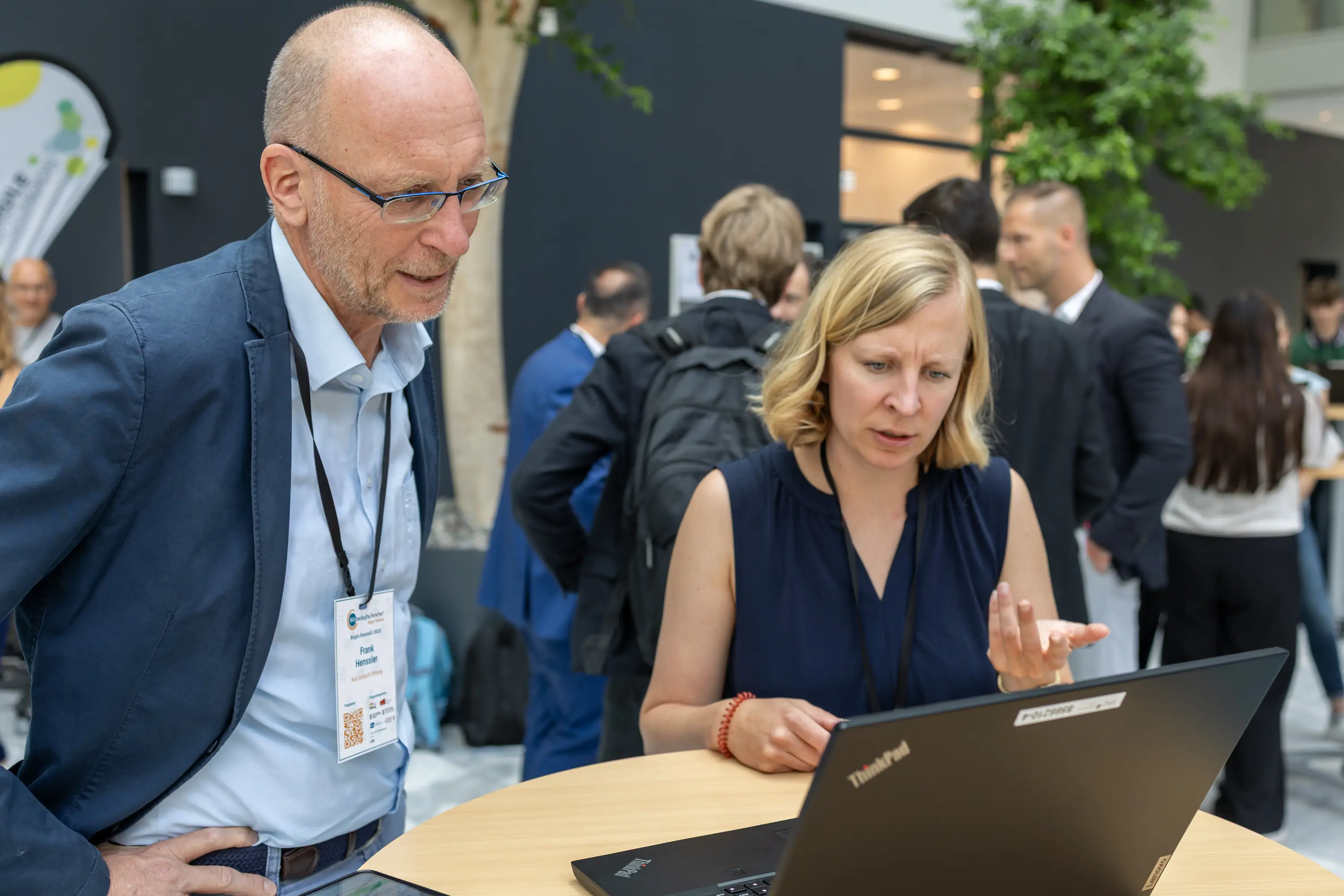 Zwei Gäste im Gespräch über ein Schülerprojekt am Laptop