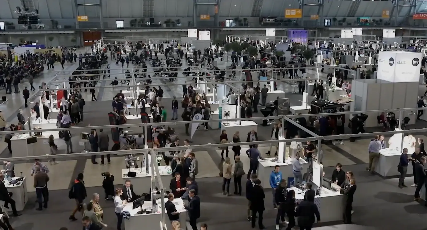 Blick von oben in eine volle Messehalle beim Start-up BW Summit